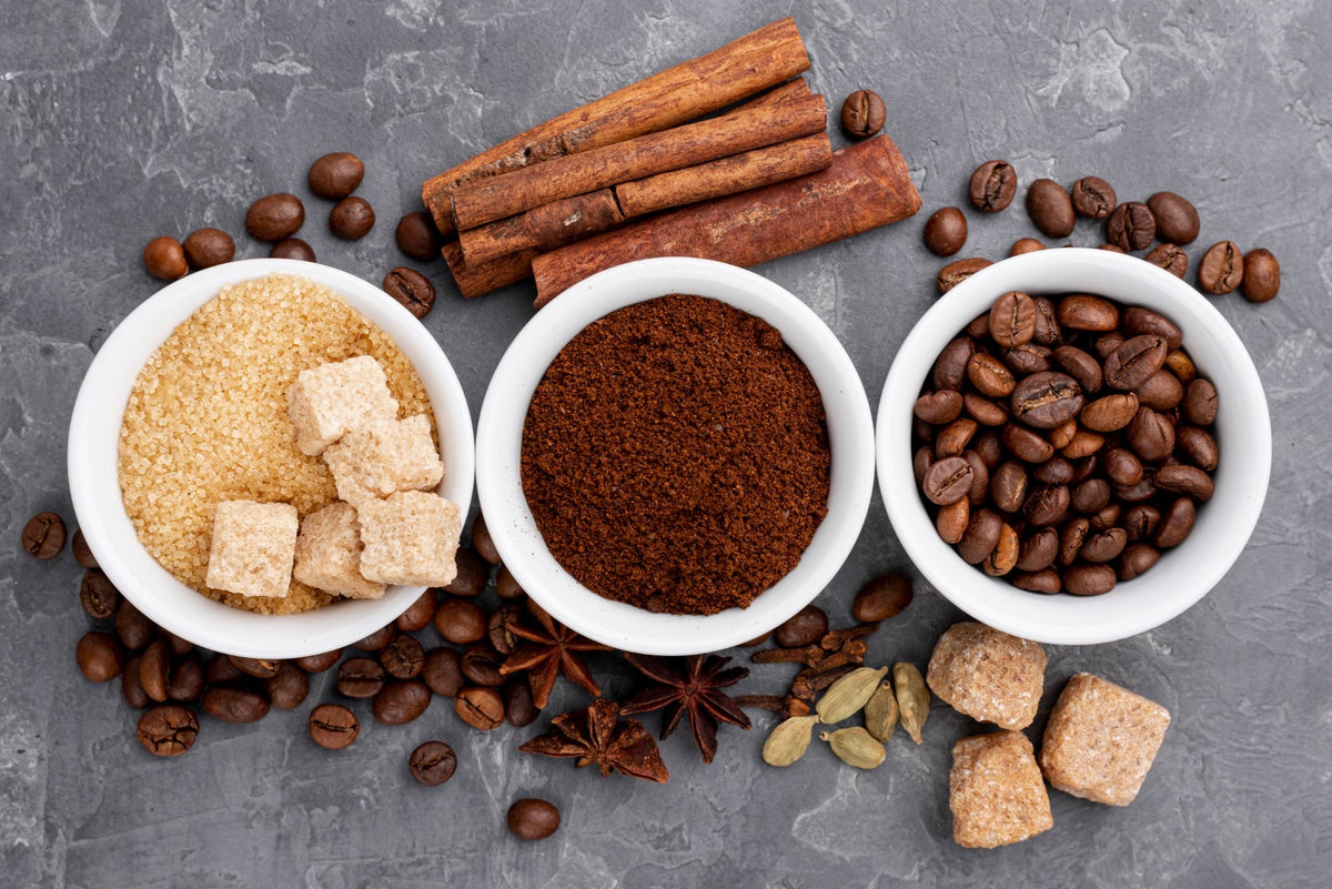 Bowls of brown sugar, ground coffee and coffee beans with cinnamon sticks and star anise
